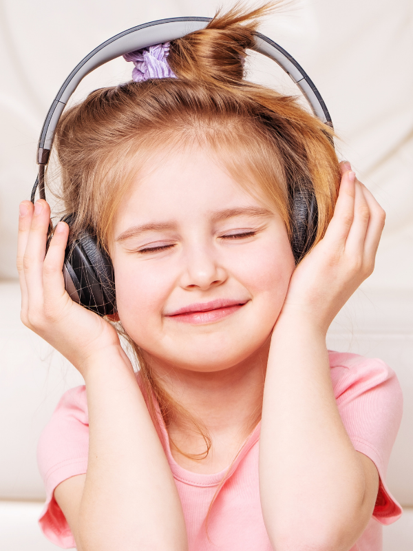 Little girl listening to the podcast with headphones